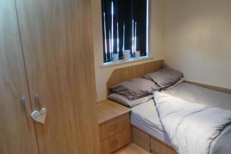 A cozy double bedroom with neutral bedding, a w...