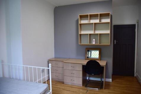 A neatly maintained student bedroom featuring a...