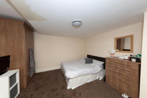 A cozy double bedroom featuring a large bed wit...