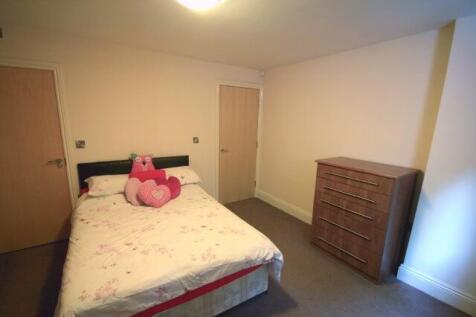A cozy bedroom featuring a double bed adorned w...