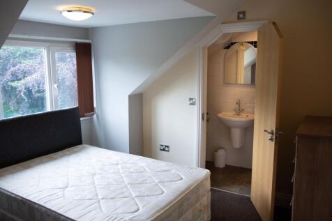 Bright and tidy bedroom featuring a large windo...
