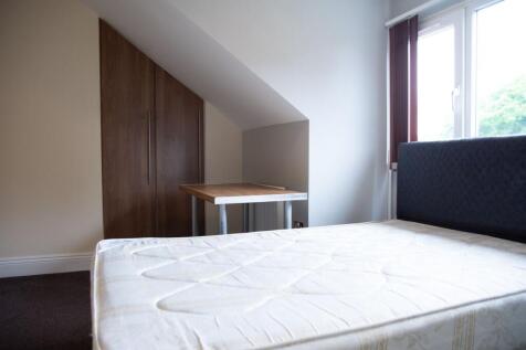 A bright, simple single bedroom featuring a win...