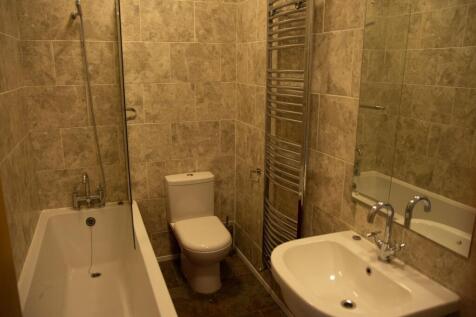 A clean and modern bathroom featuring a bathtub...