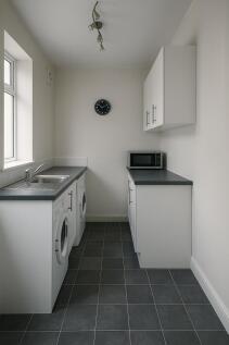 Modern and clean kitchen with white cabinets, a...