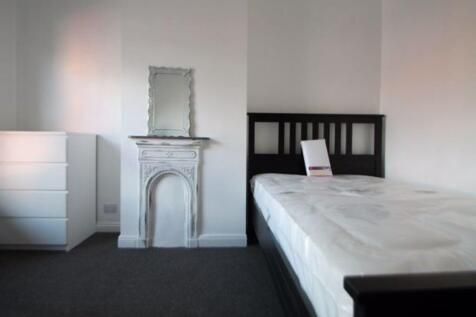A tidy single bedroom featuring a dark wood bed...