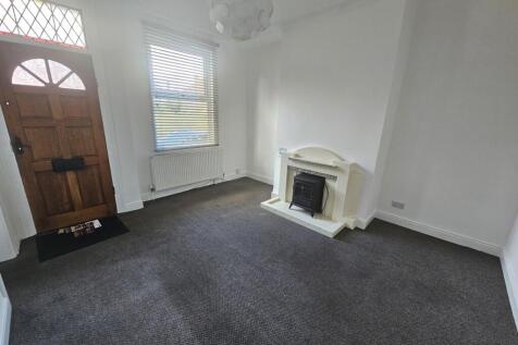 A bright and tidy living room featuring a class...