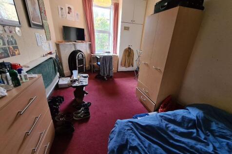 A cozy bedroom featuring a comfortable single b...