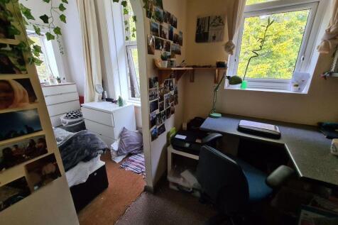 Cozy single bedroom with a study desk positione...
