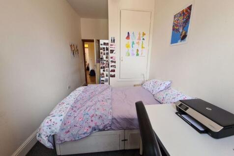 A cozy single bedroom featuring a comfortable b...