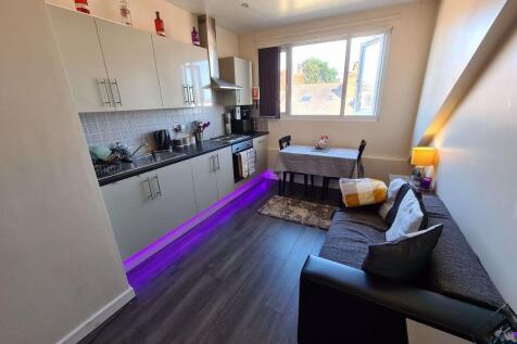 A bright, modern living room featuring a comfor...