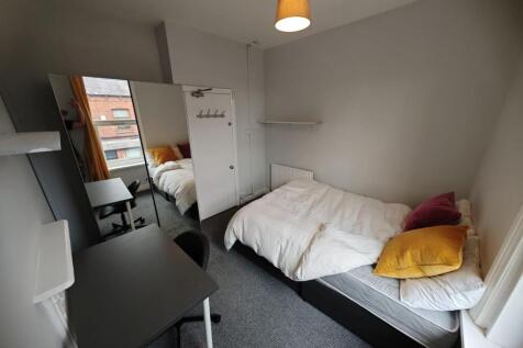 Cozy single bedroom featuring a comfortable bed...