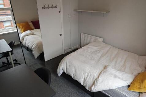 A bright and tidy single bedroom featuring a co...