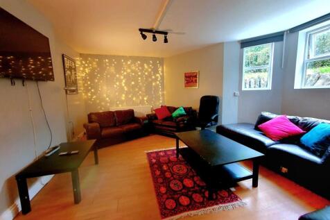 A cozy, well-lit living room featuring comforta...
