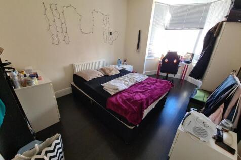 A cozy bedroom featuring a double bed with pink...