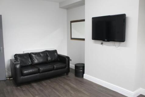 Modern living room featuring a sleek black leat...
