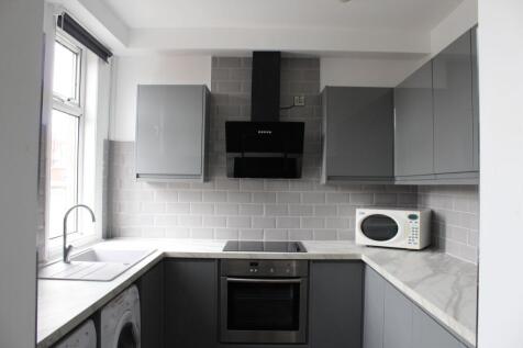 Modern and sleek kitchen featuring grey cabinet...
