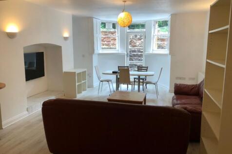 A spacious and well-lit living room featuring a...