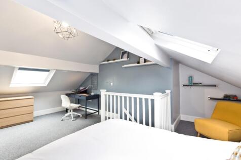 Bright and airy bedroom with skylights and neut...
