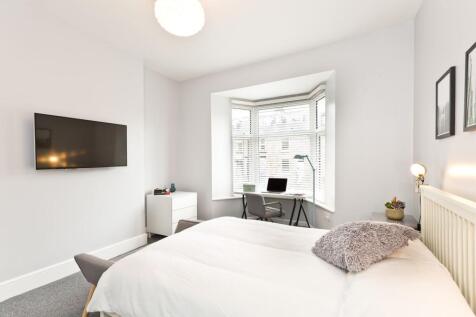 Bright, modern master bedroom with a large bay ...