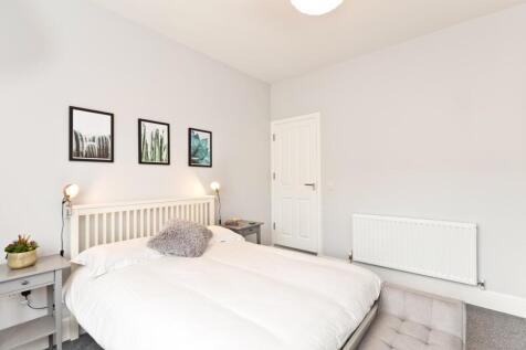 A bright, minimalistic bedroom featuring a comf...