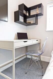 Bright, tidy bedroom workspace with a modern wh...