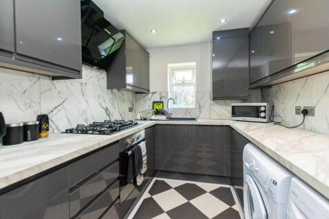 Modern and sleek kitchen with glossy grey cabin...