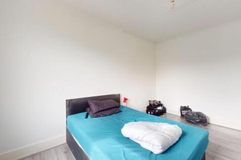 A well-lit double bedroom featuring a large bed...