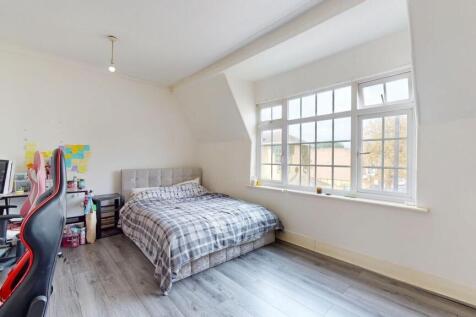 A bright and airy bedroom with a large window a...