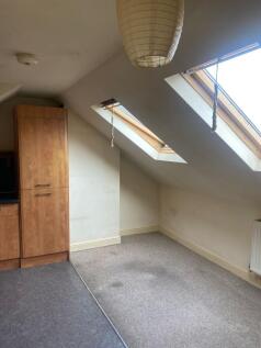 A cozy bedroom with sloped ceiling featuring sk...