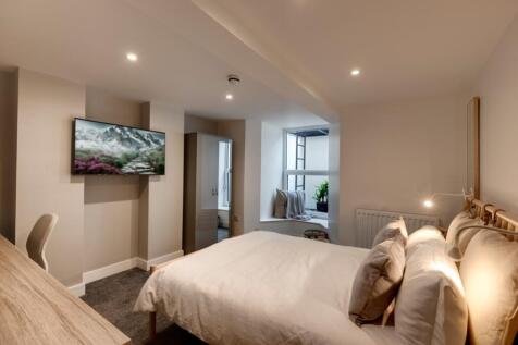 A bright and modern bedroom featuring a large b...