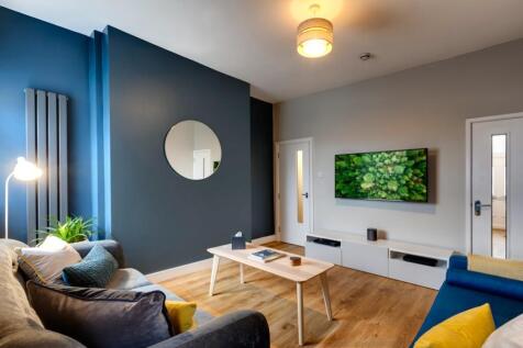 A modern, well-lit living room featuring a larg...