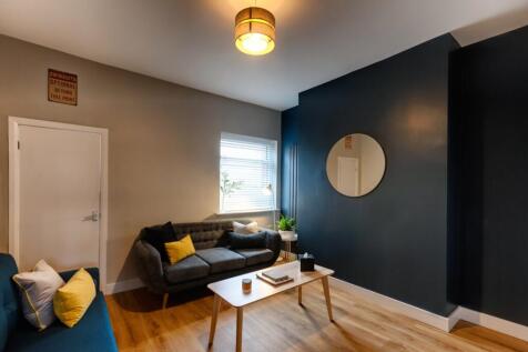 Contemporary living room with a dark accent wal...