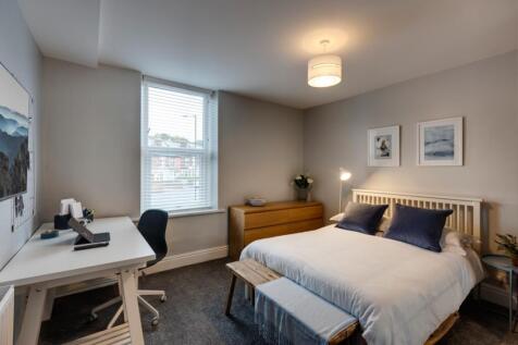 A bright and cozy bedroom featuring a comfortab...