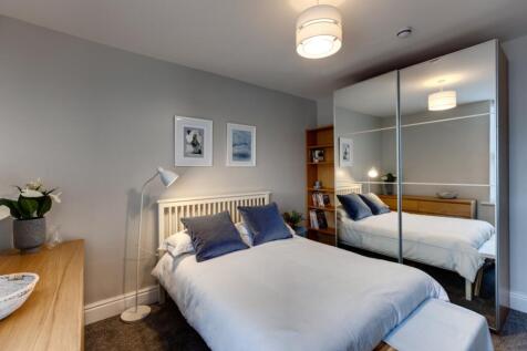 A bright, neatly presented bedroom featuring a ...