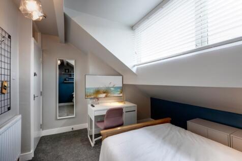 Bright and modern bedroom featuring a large win...