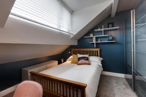 Contemporary single bedroom with a wooden bed f...
