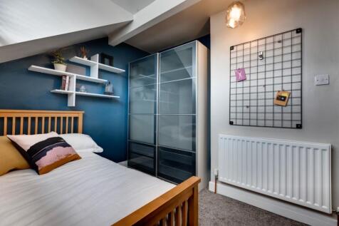 Bright, contemporary bedroom with a wooden bedf...