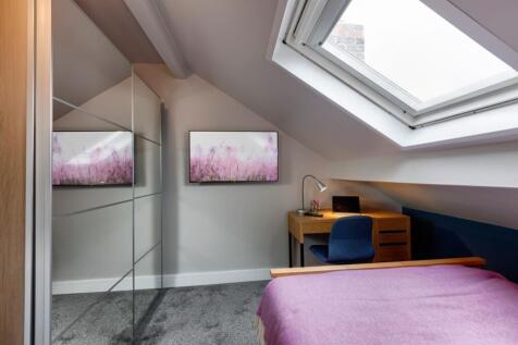 Bright and cozy bedroom featuring a sloped ceil...
