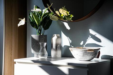 Bright, stylish entrance vignette with sculptur...