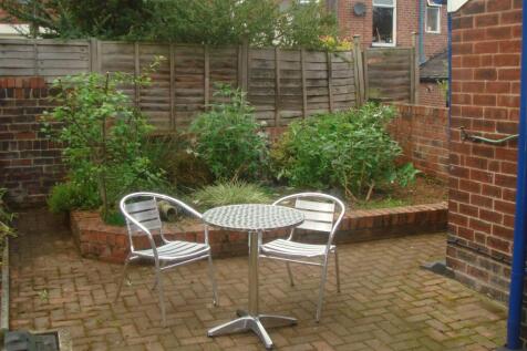 Private paved garden with a raised planted bord...