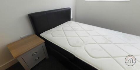 A tidy bedroom with a comfortable bed, a nights...