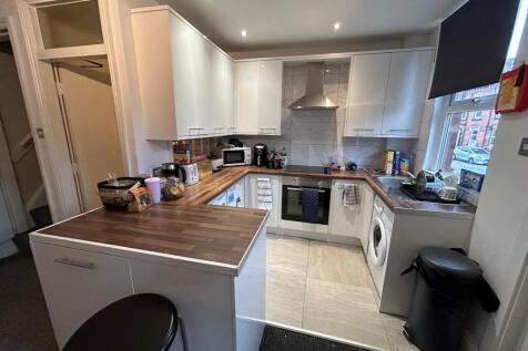 A well-maintained kitchen featuring white cabin...
