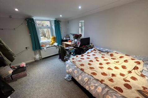 A cozy bedroom featuring a single bed and a win...