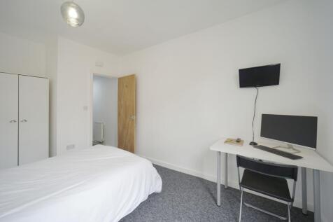 A bright and tidy bedroom featuring a comfortab...