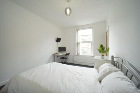 A bright and tidy bedroom featuring a comfortab...