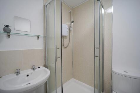 A bright, modern bathroom featuring a spacious ...