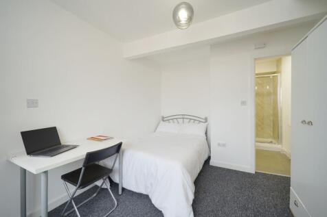 A bright and minimalist single bedroom featurin...