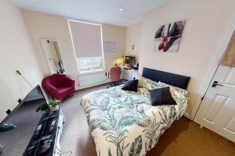 A well-lit, spacious master bedroom featuring a...