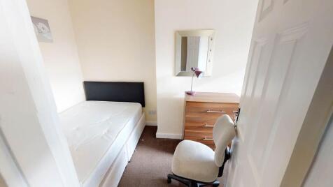A tidy and welcoming bedroom featuring a comfor...