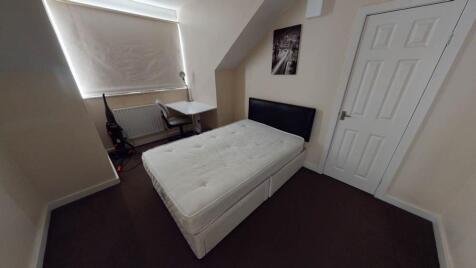 A clean and bright single bedroom featuring a c...